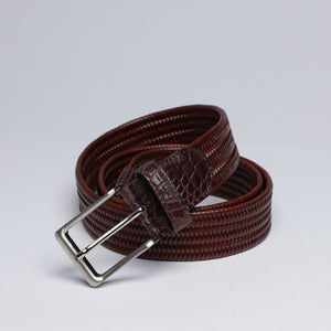Brown leather belt with a silver buckle on a light gray background
