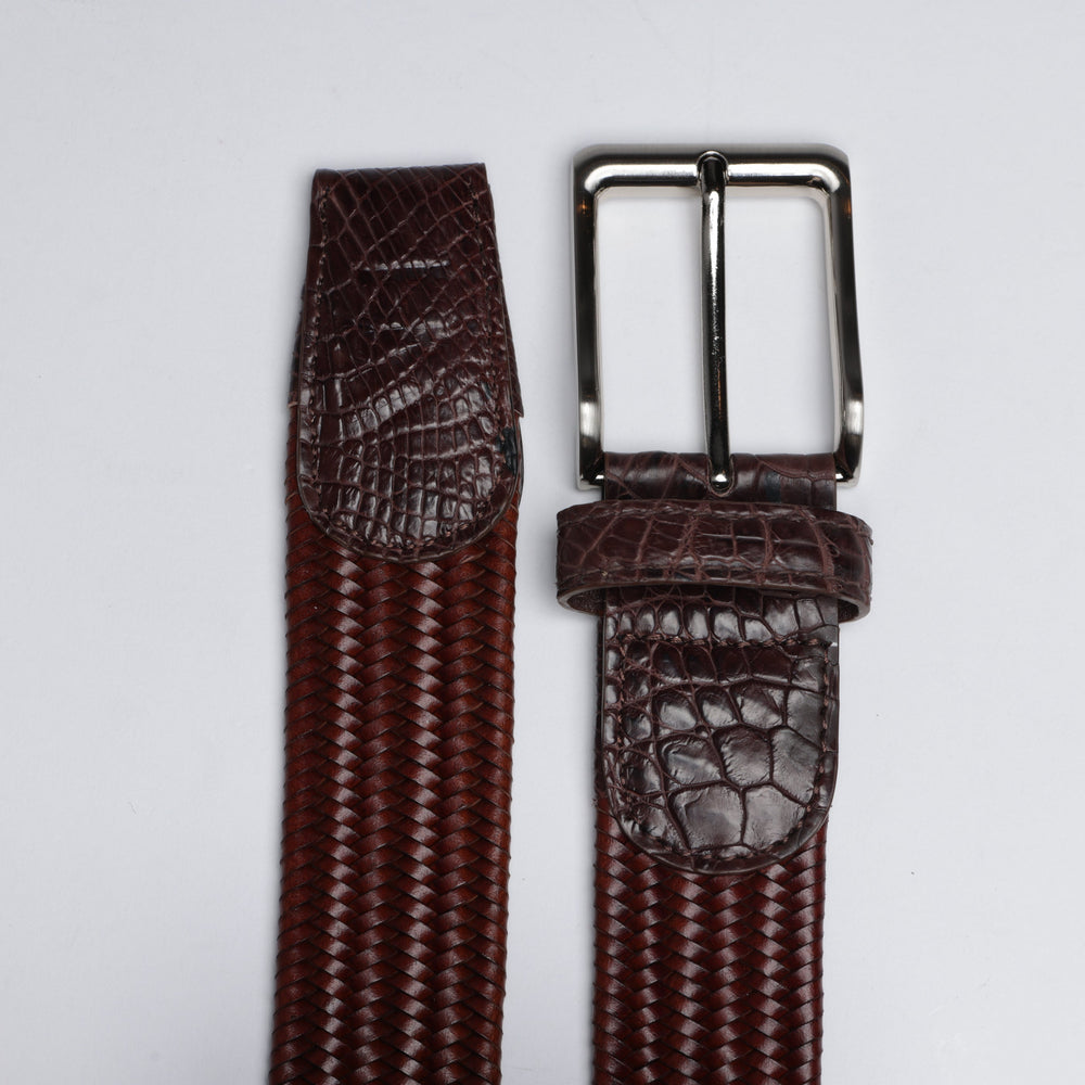 Brown textured belt with silver buckle on a light gray background